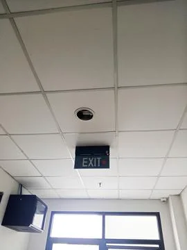 Isolated exit sign at the end of a corridor in a building Stock Photos