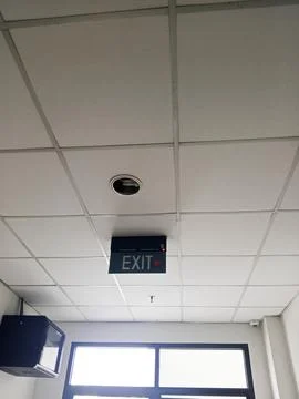 Isolated exit sign at the end of a corridor in a building Stock Photos