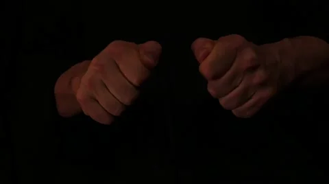 Isolated fists making approaching  hits on black background Stock Footage 58624693