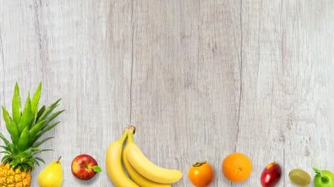 Isolated flat top view of different types of fruits on a wooden background wi Stock Photos