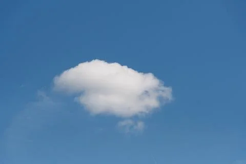 Isolated fluffy white cloud in bright blue sky Stock Photos