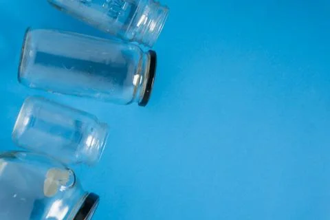 Isolated glass jars laid flat on blue background with room for copyspace on r Stock Photos
