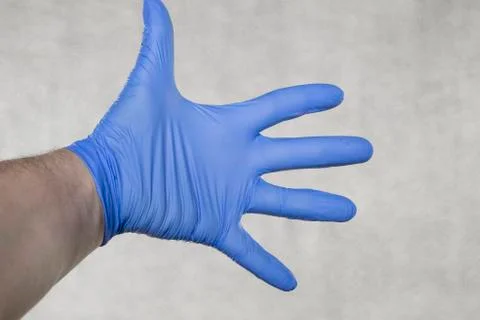 Isolated gloved hand on a gray background Stock Photos