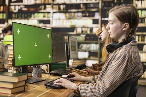 Isolated green screen on computer desktop with young woman studying Stock Photos