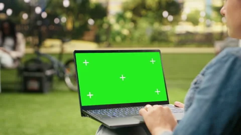Isolated green screen mockup on laptop held by casual woman in city park Stock Footage 343500762