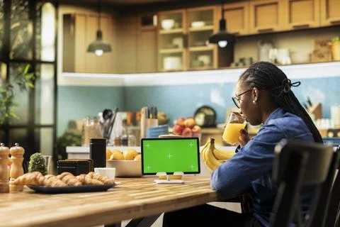 Isolated green screen on tablet screen in the sunlit kitchen at table 스톡 사진