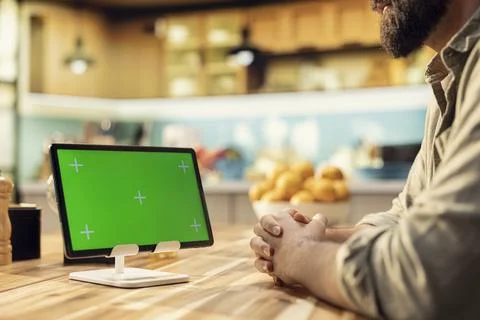Isolated green screen on tablet screen in the kitchen at wooden table Stock Photos