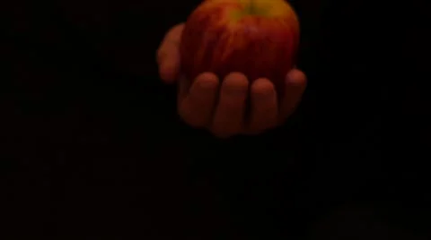 Isolated hand with apple moves on black background Stock Footage 57847068