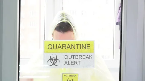 Isolated illness man standing behind a closed door in hospital room. Quarantine Video stock 131467450