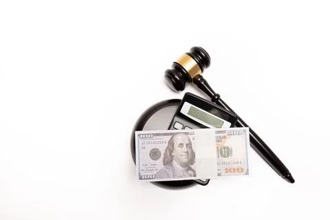 An isolated image of a judge's gavel on a stack of cash with a calculator Stock Photos