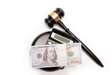 An isolated image of a judge's gavel on a stack of cash with a calculator Stock Photos