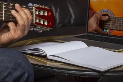 Isolated image of man's hand playing acoustic guitar and watching online cour Stock Photos