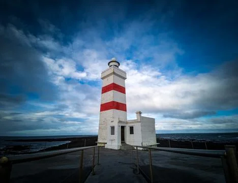 Isolated lighthouse under the cloudy sky in Iceland Foto stock