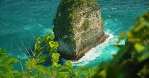 Isolated limestone rock tower stands in blue sea water in Bali Nusa Penida Stock Footage 341452804