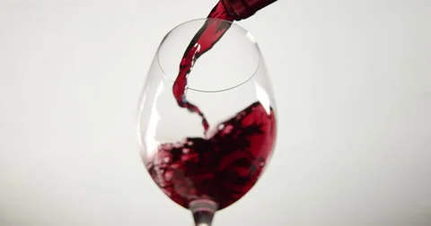 Isolated low angle slow motion shot of red wine filling a wine glass. Stock Footage 64036856