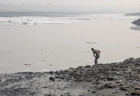 Isolated man bathing in Polluted River with Toxic Foam at misty Morning Stock Photos