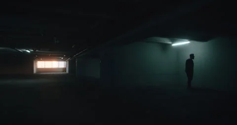 Isolated Man Under Fluorescent Light in Urban Garage Stock Footage 311920444