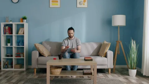 Isolated Man Uses Tablet Computer to Kill Time Stock Footage 129896244