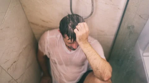 Isolated middle-aged man sitting alone in shower with wet clothes, conveyin.. Stock Footage 342961953