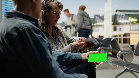 Isolated mockup smartphone held by older people in airport lounge Stock Footage 343737516