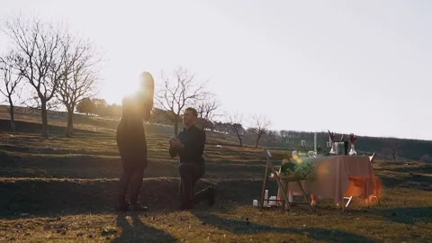 Isolated in nature, under the sunset, the man in love makes a marriage proposal Stock Footage 153461871