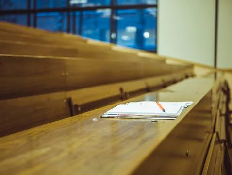Isolated notebook with pencil on the table in the empty university lecture ha Stock Photos