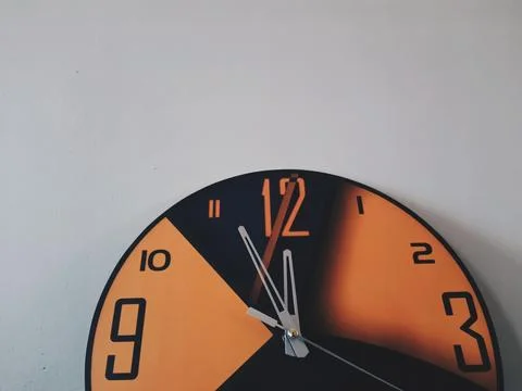 An isolated orange black wall clock Stock Photos