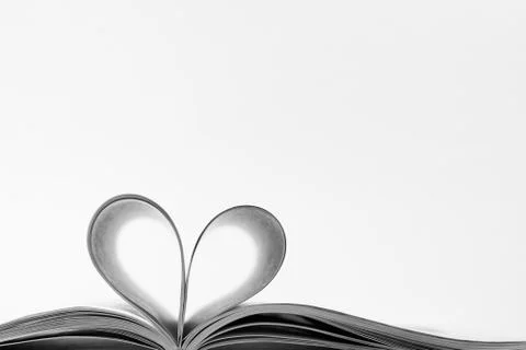 Isolated pages are folded in the shape of a heart. Romantic backdrop. Stock Photos