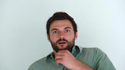 Isolated portrait over white wall background of a young dark-haired bearded Stock Footage 219663090