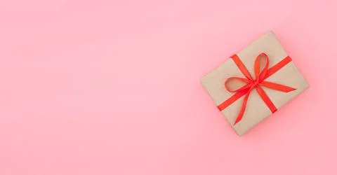 Isolated present or gift box in craft paper with red ribbon bow Stock Photos