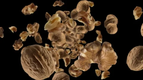 Isolated raw walnuts chunks exploding and flying in super slow motion. Pieces of Stock Footage 287344795