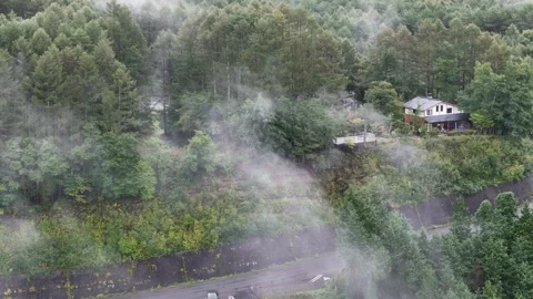 Isolated Riverside Building in a Cloudy Forested Valley 動画素材 347504731