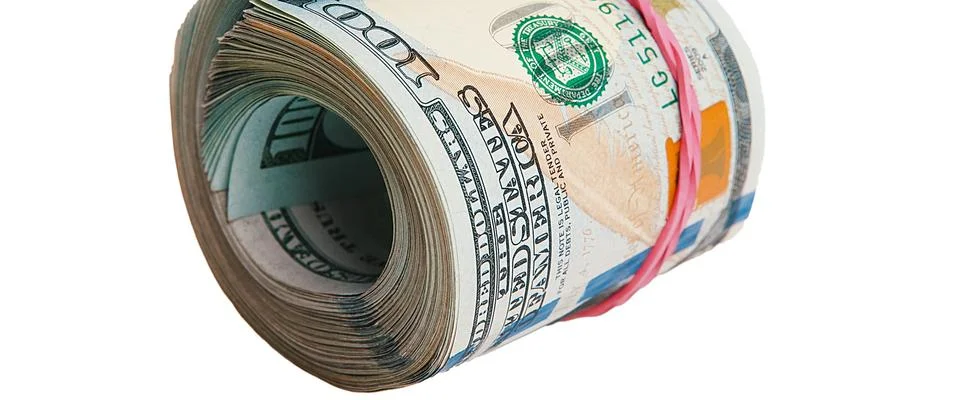 Isolated roll of dollars. A large roll of hundred-dollar bills lies on a whit Stock Photos