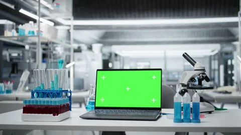 Isolated screen laptop on lab workbench next to microscope and liquid samples Stock Footage 325748355