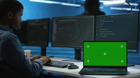Isolated screen laptop next to programmer coding in server farm Stock Photos