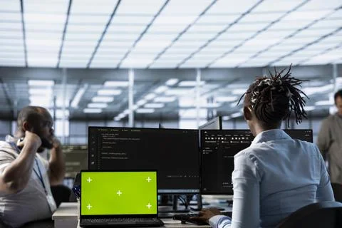 Isolated screen laptop next to system administrator coding in server farm Stock Photos
