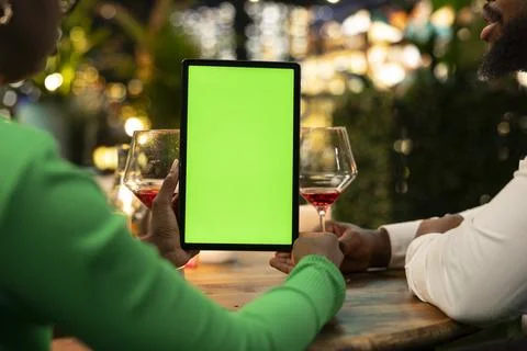 Isolated screen tablet used by couple during rooftop terrace date Fotos Stock