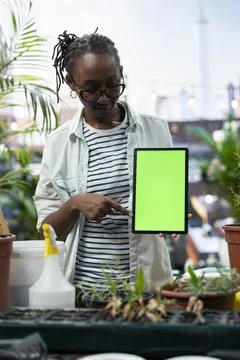 Isolated screen tablet used by woman on rooftop garden pointing toward display Stock Photos