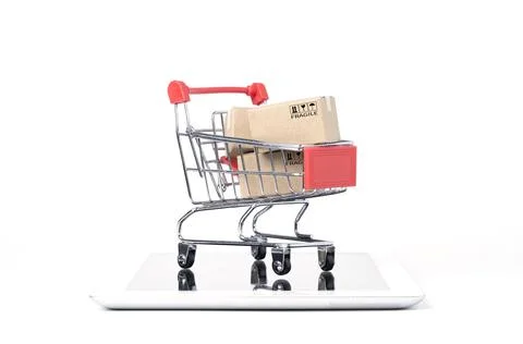 Isolated of Shipping paper boxes inside Red shopping cart trolley on tablet Stock Photos