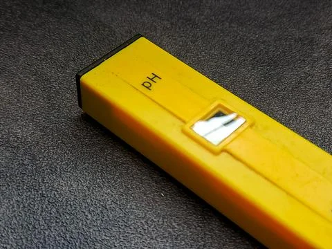 Isolated shot capturing a sleek, yellow pH meter displayed diagonally on a .. Stock Photos