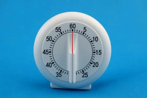 Isolated shot of kitchen mechanical timer on a blue background 스톡 사진