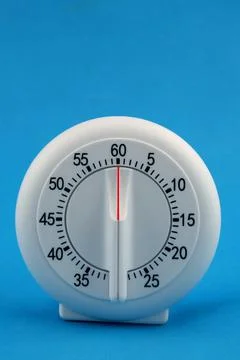 Isolated shot of kitchen mechanical timer on a blue background Stock Photos