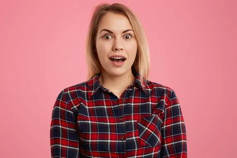 Isolated shot of surprised light haired young woman keeps mouth widely open.. Stock Photos
