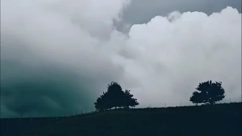 Isolated Silhouetted Trees on Hill Under Dark Storm Clouds Stock Footage 319415430