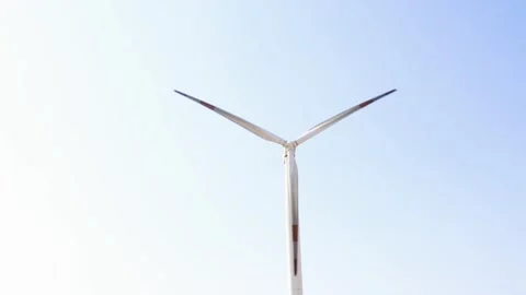 Isolated single wind turbine generating renewable energy against clear blue s 動画素材 331044079