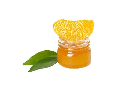 Isolated slice of mandarin with tangerine jam and green leaves on a white bac Stock Photos