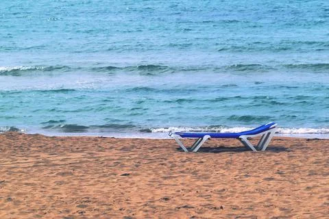Isolated sunbed on the sandy coast Stock Photos
