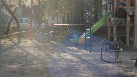 Isolated swing at empty playground behind restrictive tapes in Eastern Europe Stock-Footage 129240320