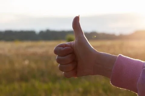 Isolated Thumb up at sunset in field Stock Photos