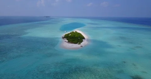 Isolated tiny island with lush vegetation and azure turquoise lagoon Vídeos de archivo 120003651